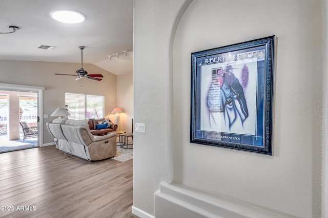 interior space with visible vents, lofted ceiling, wood finished floors, ceiling fan, and track lighting