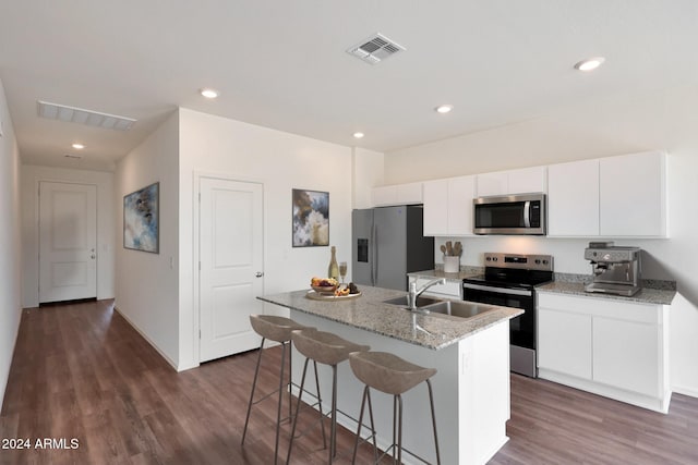 kitchen featuring white cabinetry, sink, stainless steel appliances, dark hardwood / wood-style flooring, and a kitchen island with sink