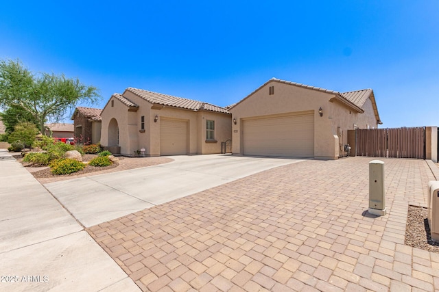 5541 W Desperado Way, Phoenix, AZ 85083 - mediterranean / spanish home featuring an attached garage, driveway, stucco siding, a tiled roof, and a gate
