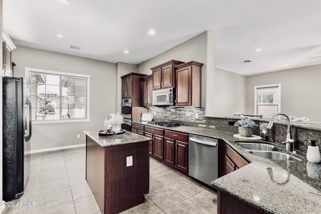 5541 W Desperado Way, Phoenix, AZ 85083 - kitchen with appliances with stainless steel finishes, a sink, stone counters, backsplash, and light tile patterned floors