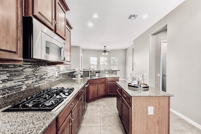 5541 W Desperado Way, Phoenix, AZ 85083 - kitchen featuring stainless steel appliances, a sink, tasteful backsplash, ceiling fan, and light tile patterned floors
