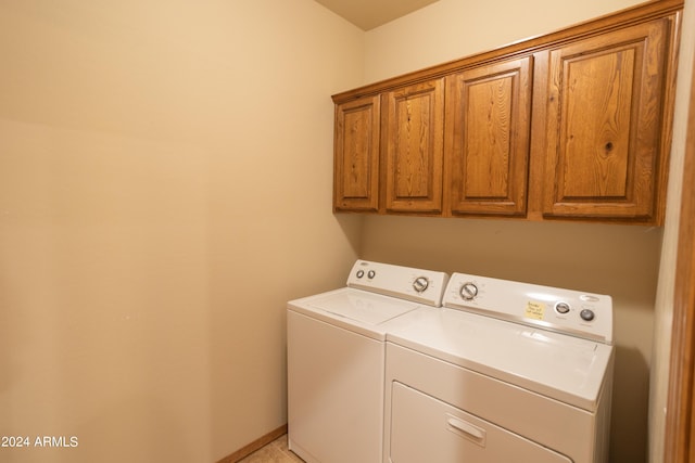 washroom with cabinet space, baseboards, and washer and dryer