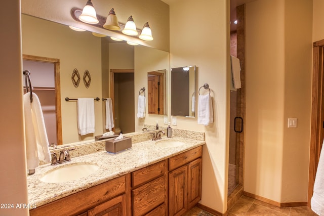 full bath featuring double vanity, a shower stall, a sink, and tile patterned floors