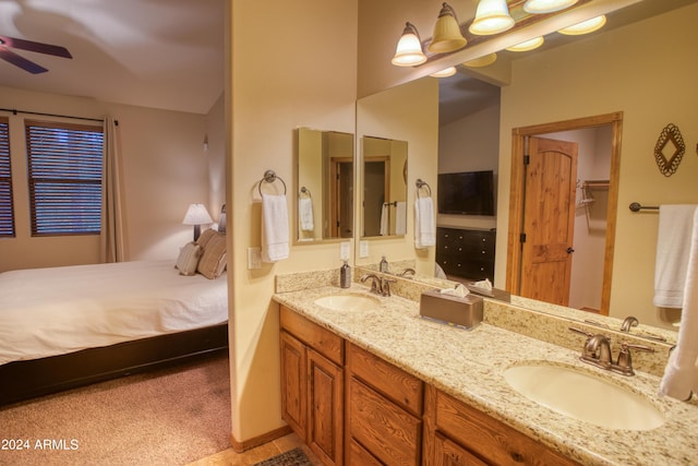 bathroom with double vanity, ceiling fan, a sink, and ensuite bathroom