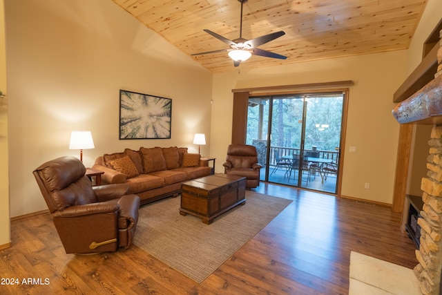 living room with baseboards, wooden ceiling, wood finished floors, vaulted ceiling, and a stone fireplace