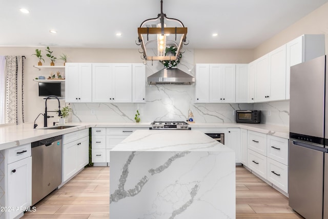 kitchen featuring tasteful backsplash, a center island, light wood-style floors, stainless steel appliances, and a sink