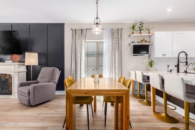 dining area featuring light wood-type flooring and a fireplace