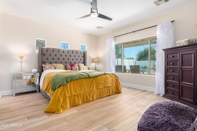 bedroom featuring a ceiling fan, light wood-style flooring, baseboards, and visible vents