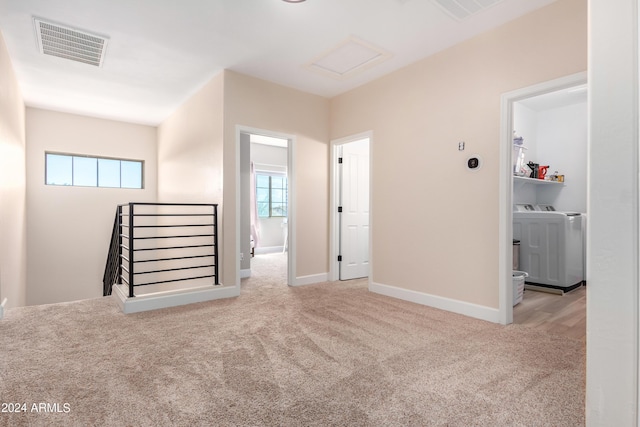 interior space featuring visible vents, an upstairs landing, separate washer and dryer, carpet flooring, and attic access