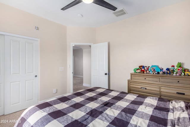 bedroom with a closet, ceiling fan, and light carpet