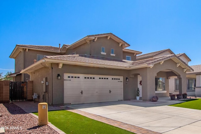 view of front of home featuring a gate, fence, stucco siding, concrete driveway, and a tile roof