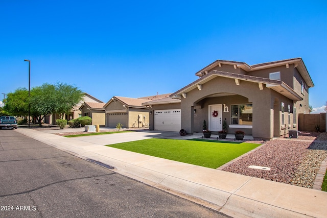 view of front of property with stucco siding, driveway, a front lawn, fence, and an attached garage