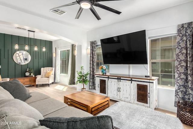 living room featuring light hardwood / wood-style flooring and ceiling fan