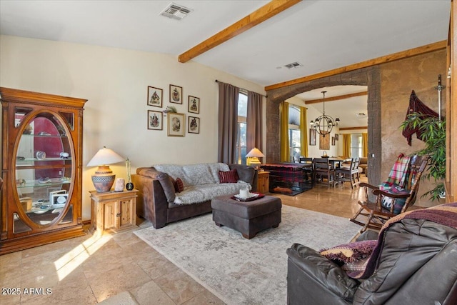 living room featuring beamed ceiling, an inviting chandelier, and plenty of natural light