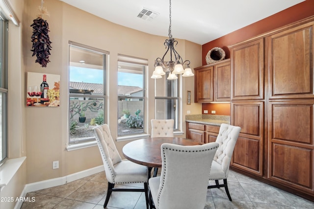 tiled dining area with a chandelier