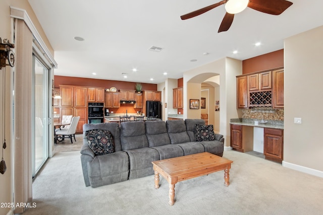 living room featuring light carpet and ceiling fan