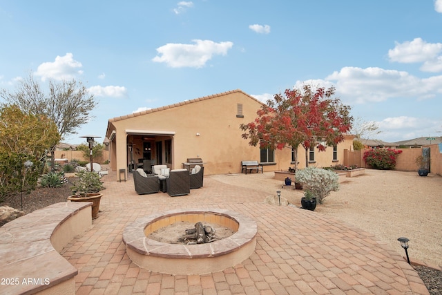 rear view of house featuring a patio area and an outdoor living space with a fire pit