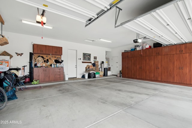 garage featuring water heater, a garage door opener, and a workshop area