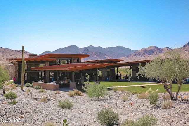 rear view of property featuring a lawn and a mountain view