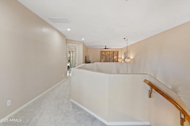 hallway with a notable chandelier and light carpet