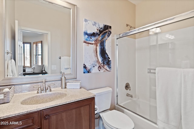 full bathroom featuring shower / bath combination with glass door, toilet, and vanity