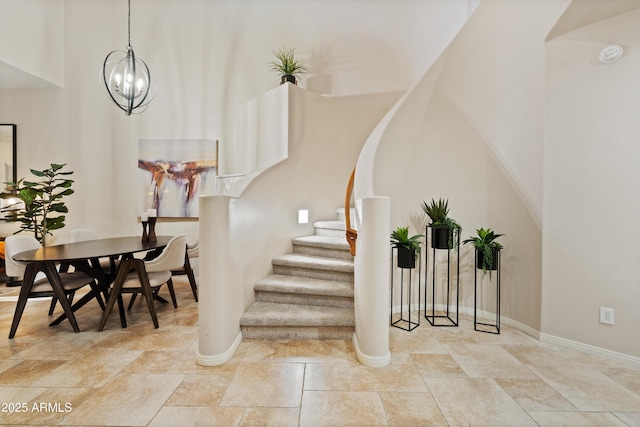 stairs featuring a chandelier