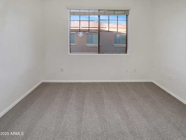carpeted empty room featuring baseboards