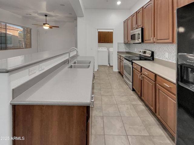 kitchen with separate washer and dryer, light tile patterned flooring, a sink, a ceiling fan, and appliances with stainless steel finishes