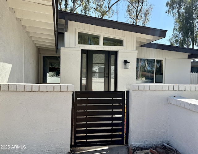 view of exterior entry featuring a gate and fence