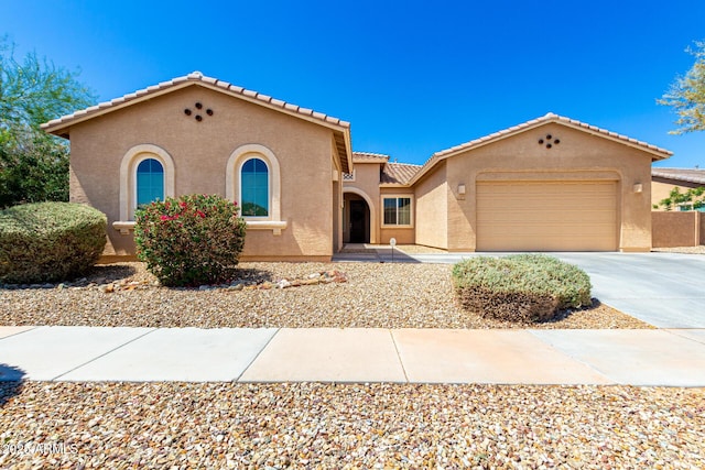 16860 W Soft Wind Dr, Surprise, AZ 85387 - mediterranean / spanish-style house featuring stucco siding, a garage, driveway, and a tile roof