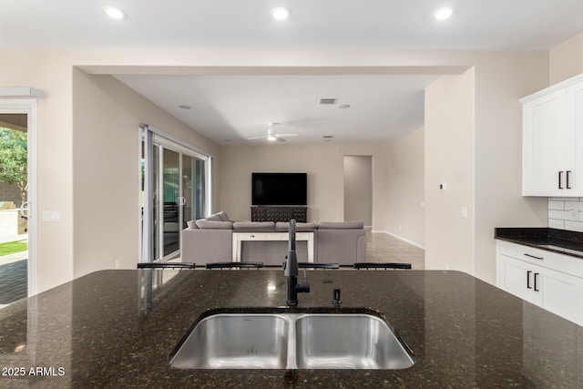 16860 W Soft Wind Dr, Surprise, AZ 85387 - kitchen featuring a sink, white cabinetry, dark stone countertops, recessed lighting, and open floor plan
