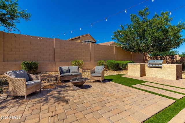 16860 W Soft Wind Dr, Surprise, AZ 85387 - view of patio / terrace featuring an outdoor kitchen, grilling area, a fenced backyard, and an outdoor living space with a fire pit