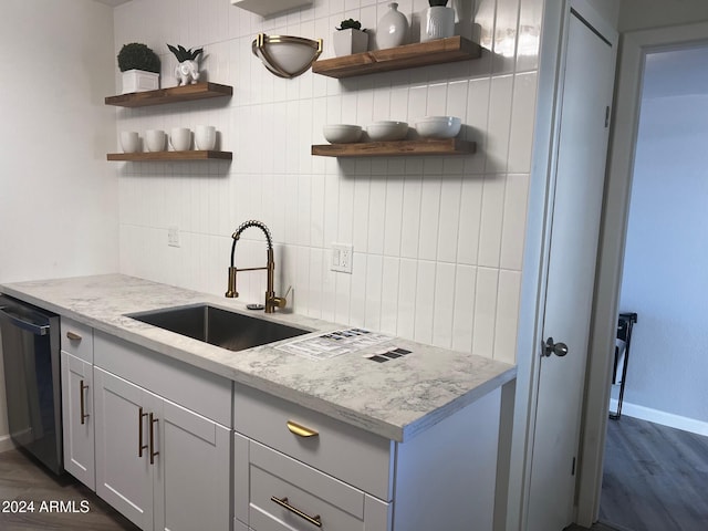 kitchen with dishwasher, dark hardwood / wood-style floors, light stone counters, and tasteful backsplash