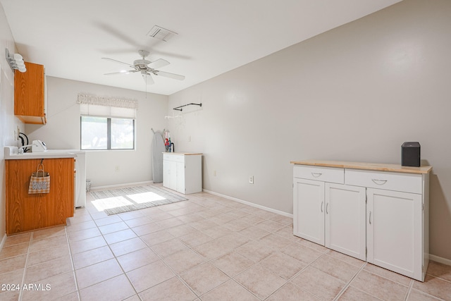 interior space with white cabinets, ceiling fan, and light tile patterned floors