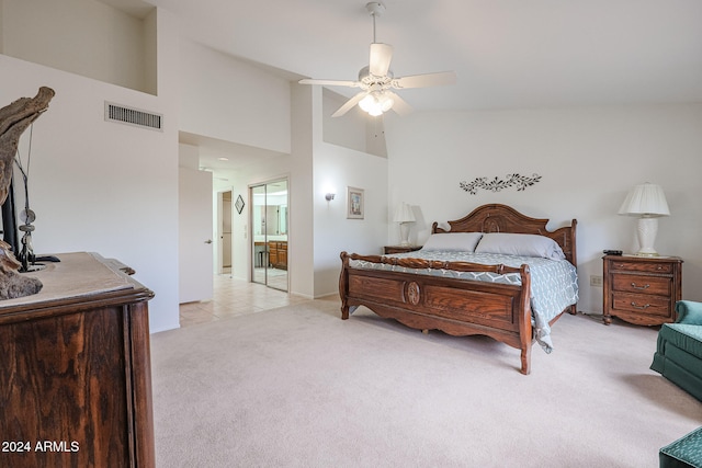 carpeted bedroom with high vaulted ceiling, ceiling fan, and ensuite bath