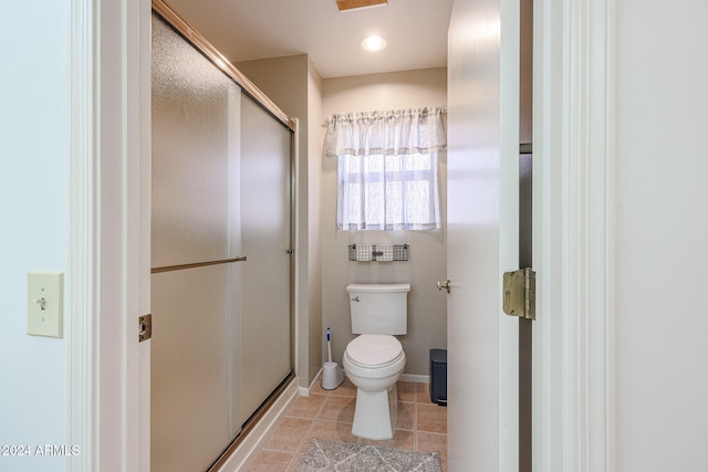 bathroom featuring walk in shower, toilet, and tile patterned flooring