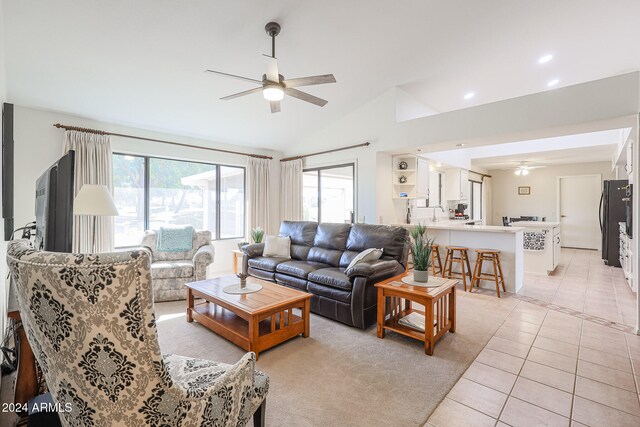 tiled living room with ceiling fan and lofted ceiling