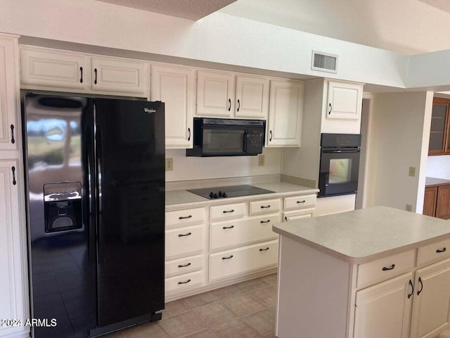 kitchen featuring light tile patterned floors, black appliances, and a kitchen island