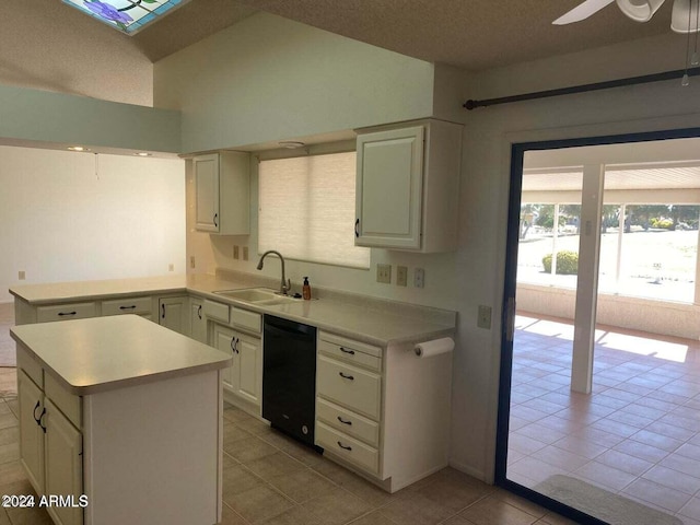 kitchen featuring vaulted ceiling, dishwasher, sink, light tile patterned floors, and a kitchen island