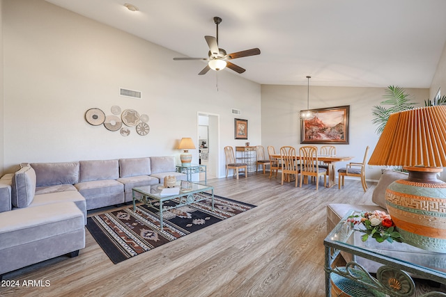 living room with hardwood / wood-style flooring, ceiling fan, and lofted ceiling