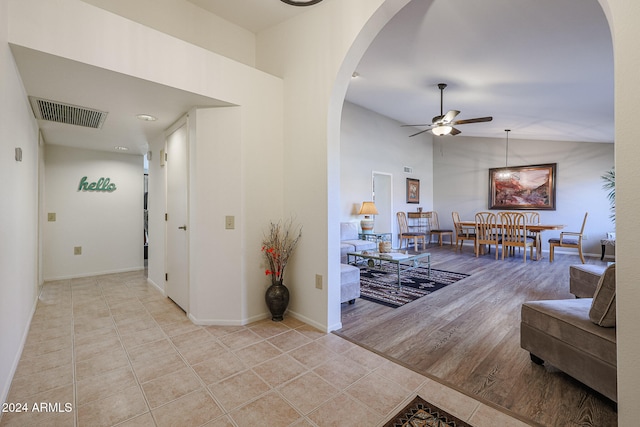 hall with light wood-type flooring and lofted ceiling