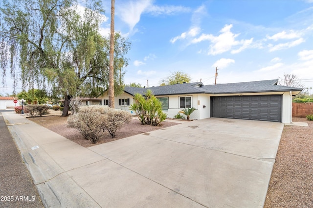 ranch-style house featuring a garage and driveway