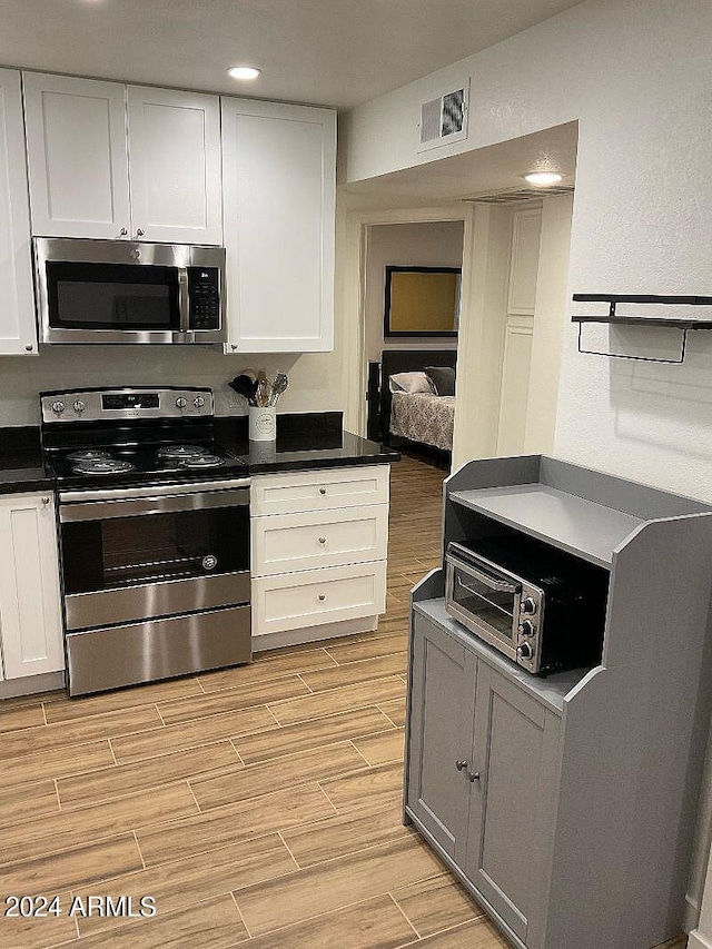 kitchen with white cabinetry and appliances with stainless steel finishes