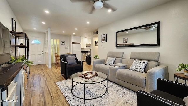 living room with ceiling fan and light wood-type flooring