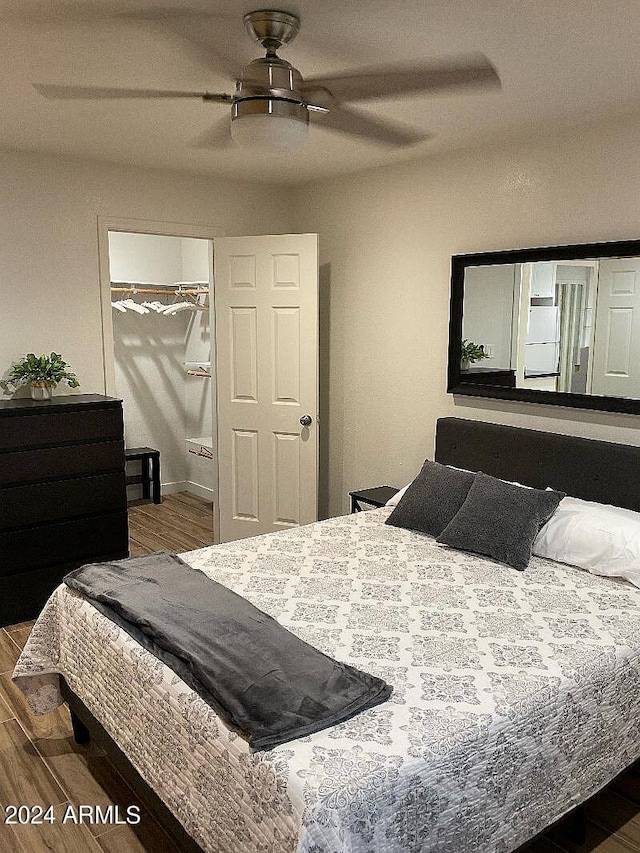 bedroom featuring hardwood / wood-style flooring, ceiling fan, and a closet