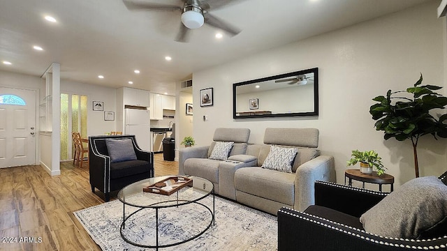 living room with ceiling fan and light hardwood / wood-style flooring