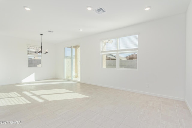 unfurnished room featuring an inviting chandelier