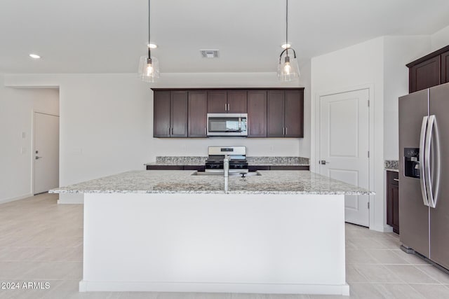 kitchen with pendant lighting, an island with sink, and stainless steel appliances