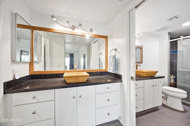 bathroom with vanity, toilet, tile patterned floors, and a shower with shower door