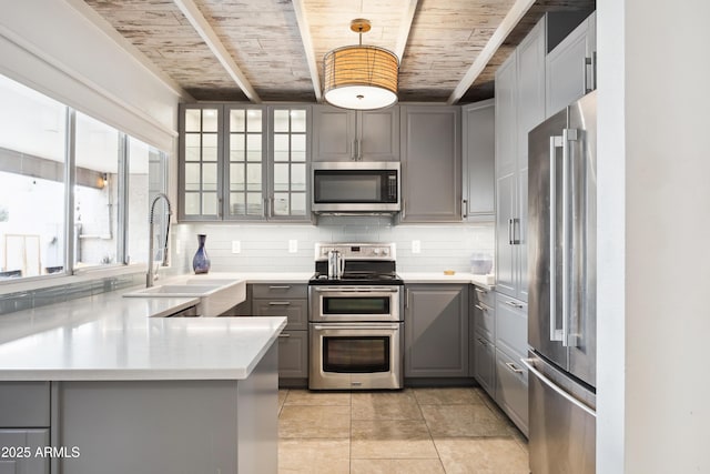 kitchen featuring decorative backsplash, wooden ceiling, stainless steel appliances, gray cabinets, and a sink